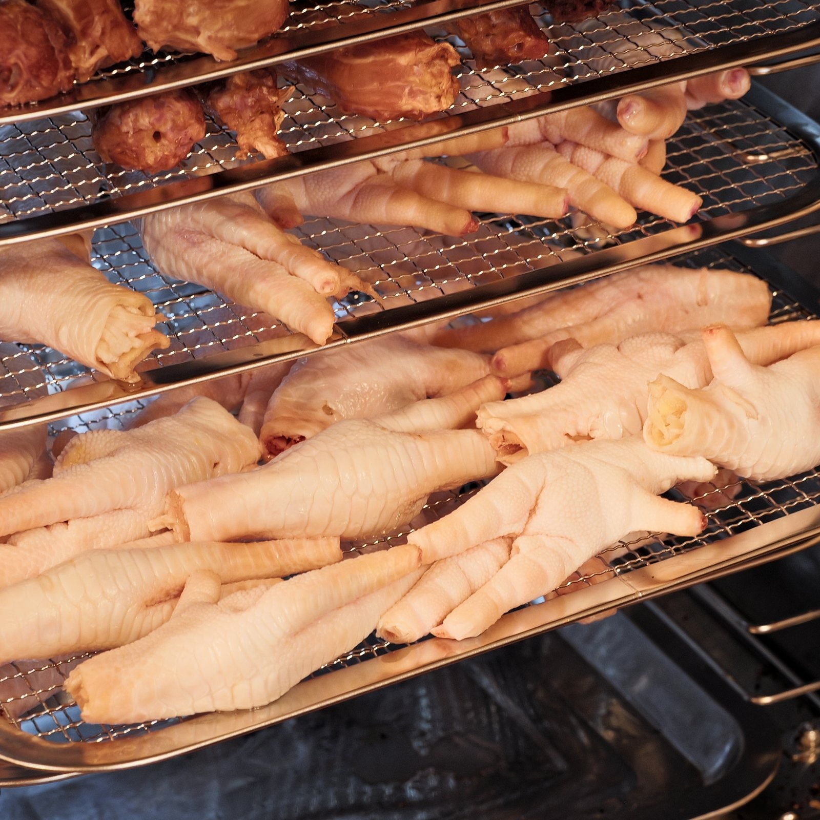 Chicken feet single-ingredient dog chews laid out on drying racks in Honey's Small Kitchen
